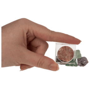 Mineraliniai akmenys dėžutėje su didinamuoju stiklu